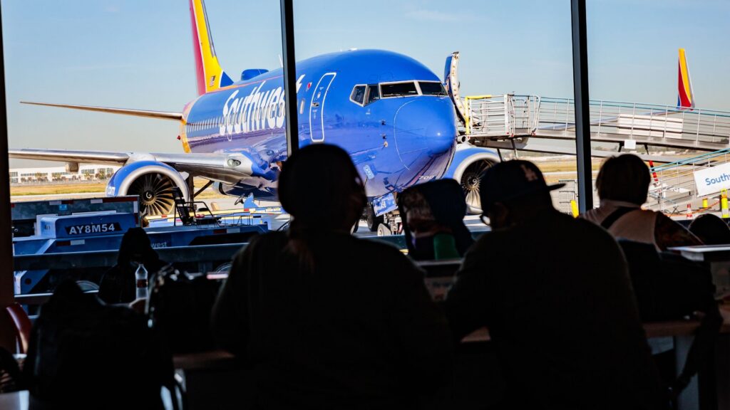 Passengers wait for their flights near the Southwest Airlines gate inside of the Long Beach Airport concourse.